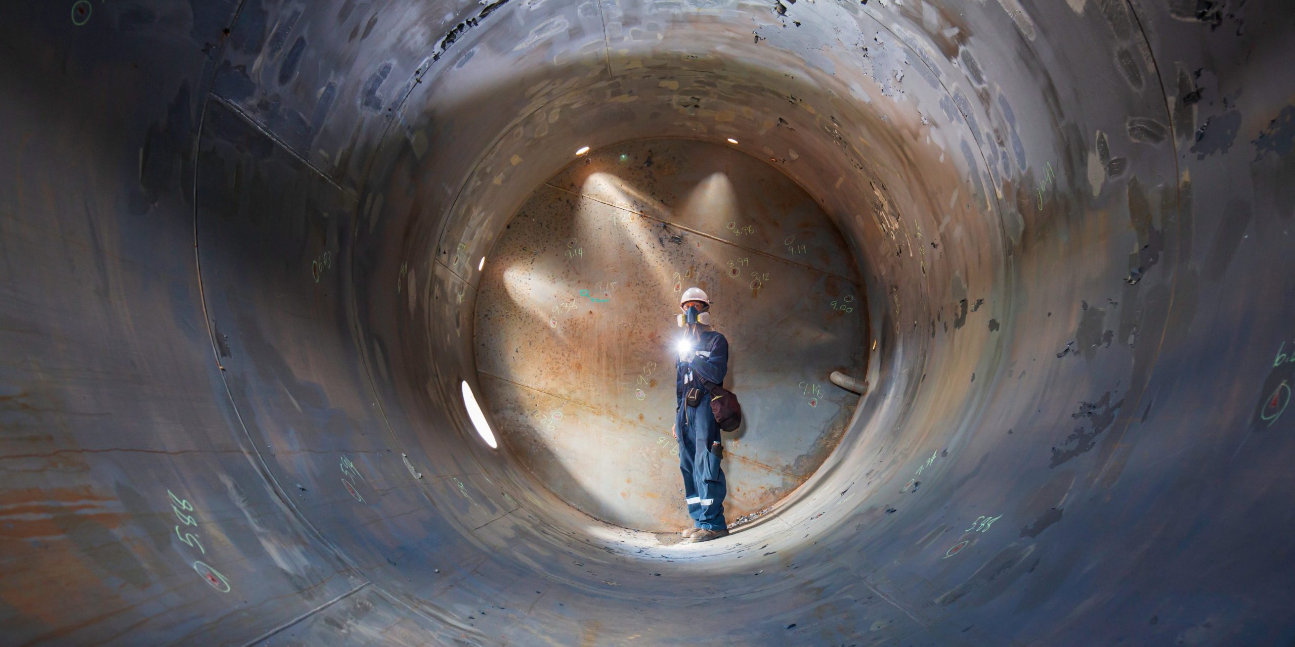 Confined Space Operations Showing A Worker Inspecting An Underground Of Equipment Tunnel