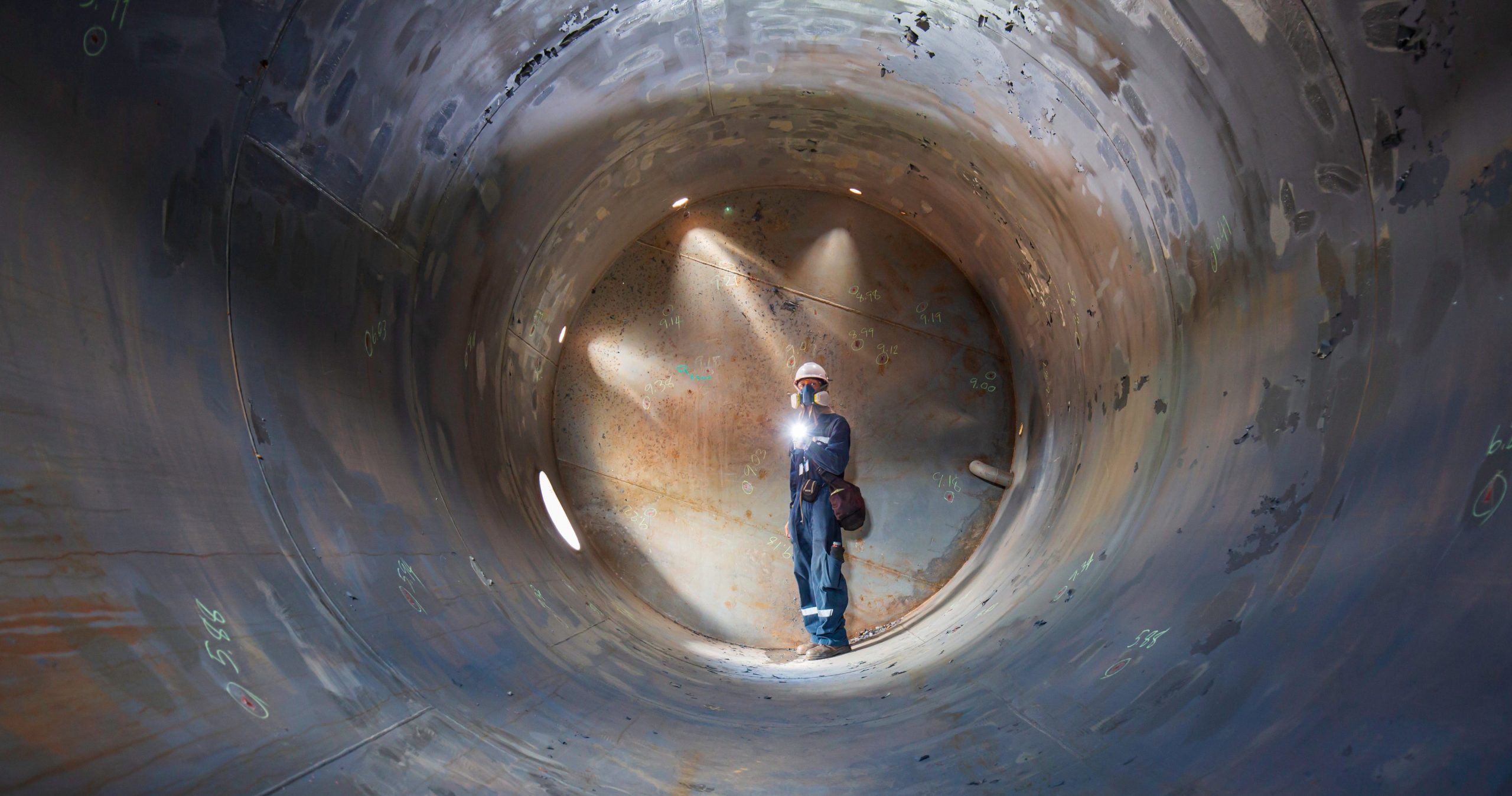 Confined Space Operations Showing A Worker Inspecting An Underground Of Equipment Tunnel