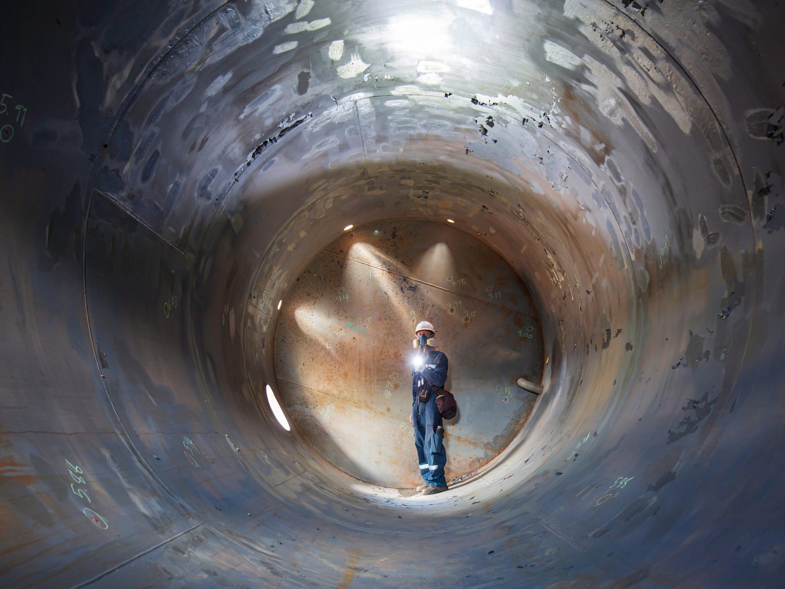 Confined Space Operations Showing A Worker Inspecting An Underground Of Equipment Tunnel